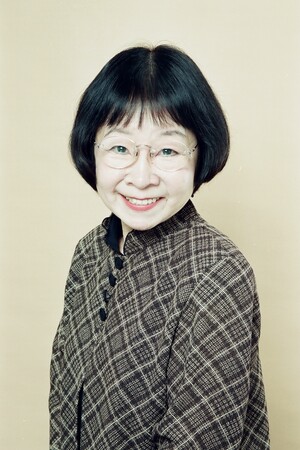 Smiling headshot of Junko Hori with a patterned button-up shirt and glasses